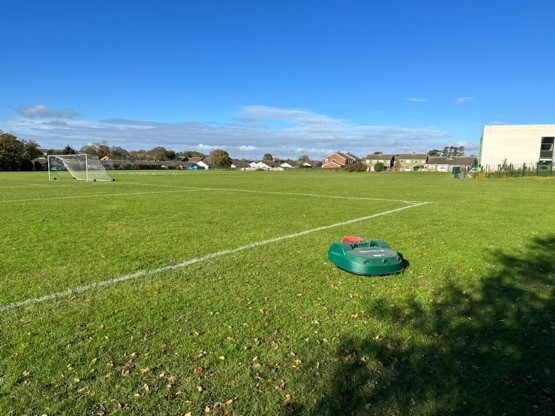 robotic mower cutting football pitch